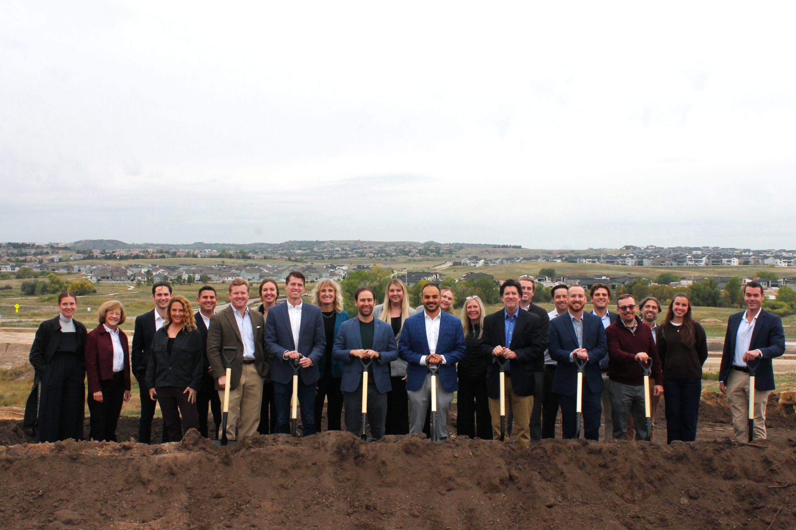 Ulysses Development Group team at a groundbreaking event, posing with shovels on a construction site for housing development