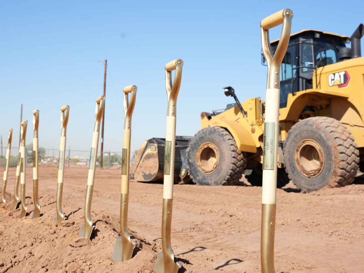 shovels in ground lined up with loader in background