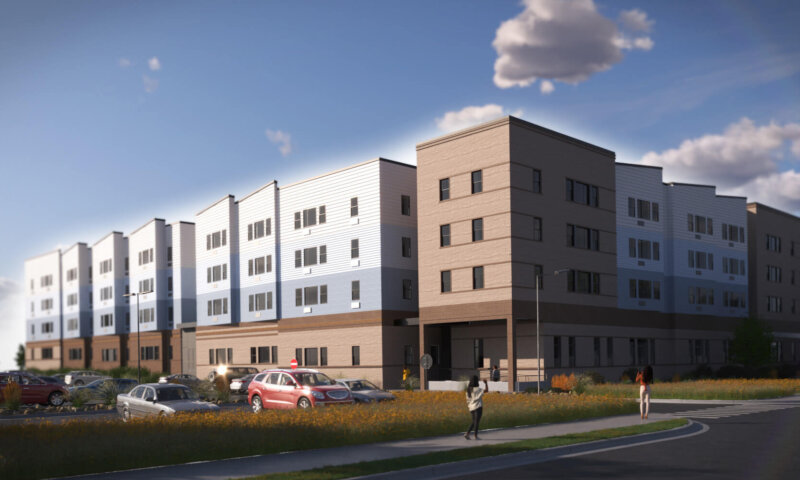 Modern apartment building with parking lot and pedestrians.