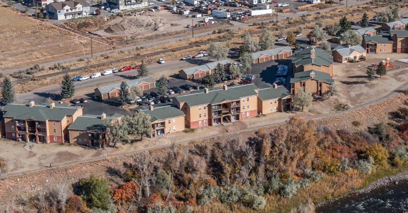 Aerial view of Eagle Villas residential complex near wooded area.