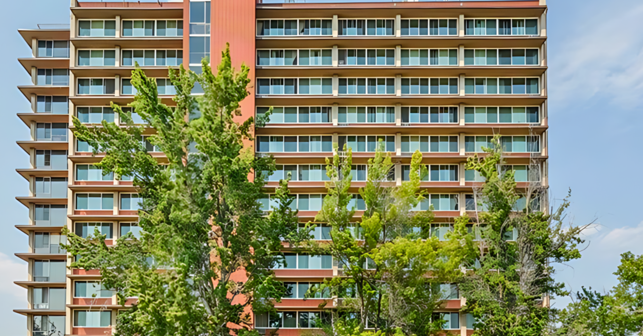 A multistory apartment building with trees in front.